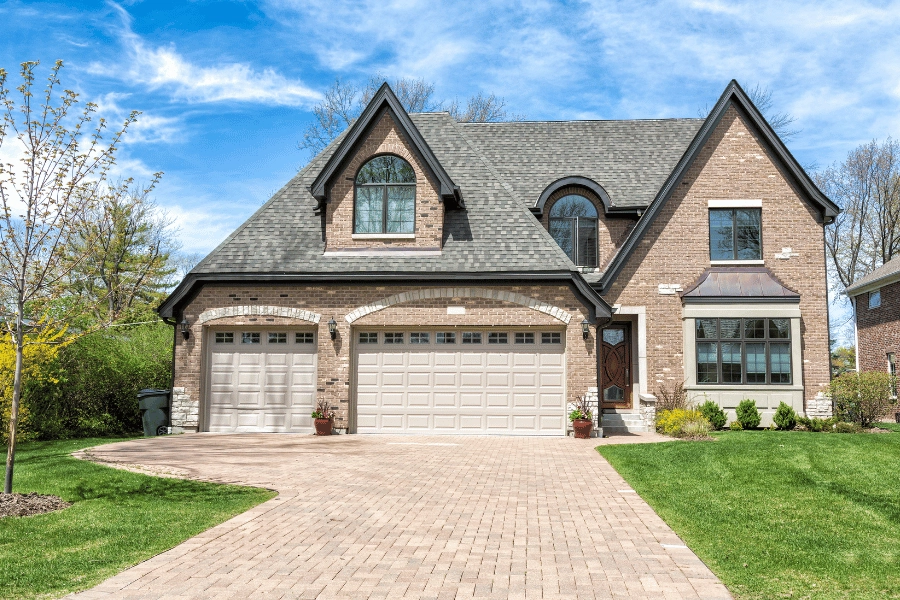 traditional large home with two garages and brick exterior